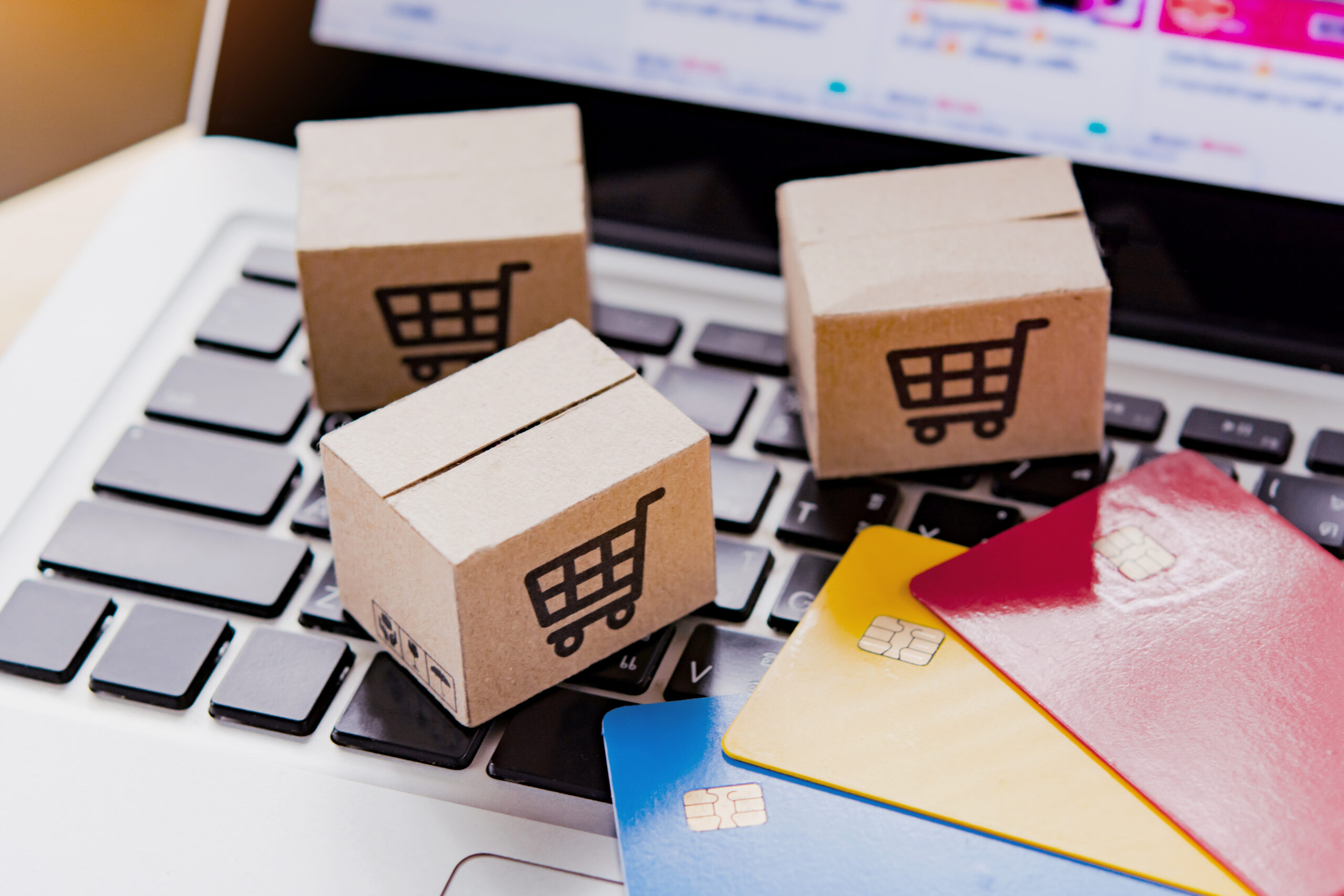 eCommerce Awards UK - cardboard boxes with shopping trolley icons on laptop