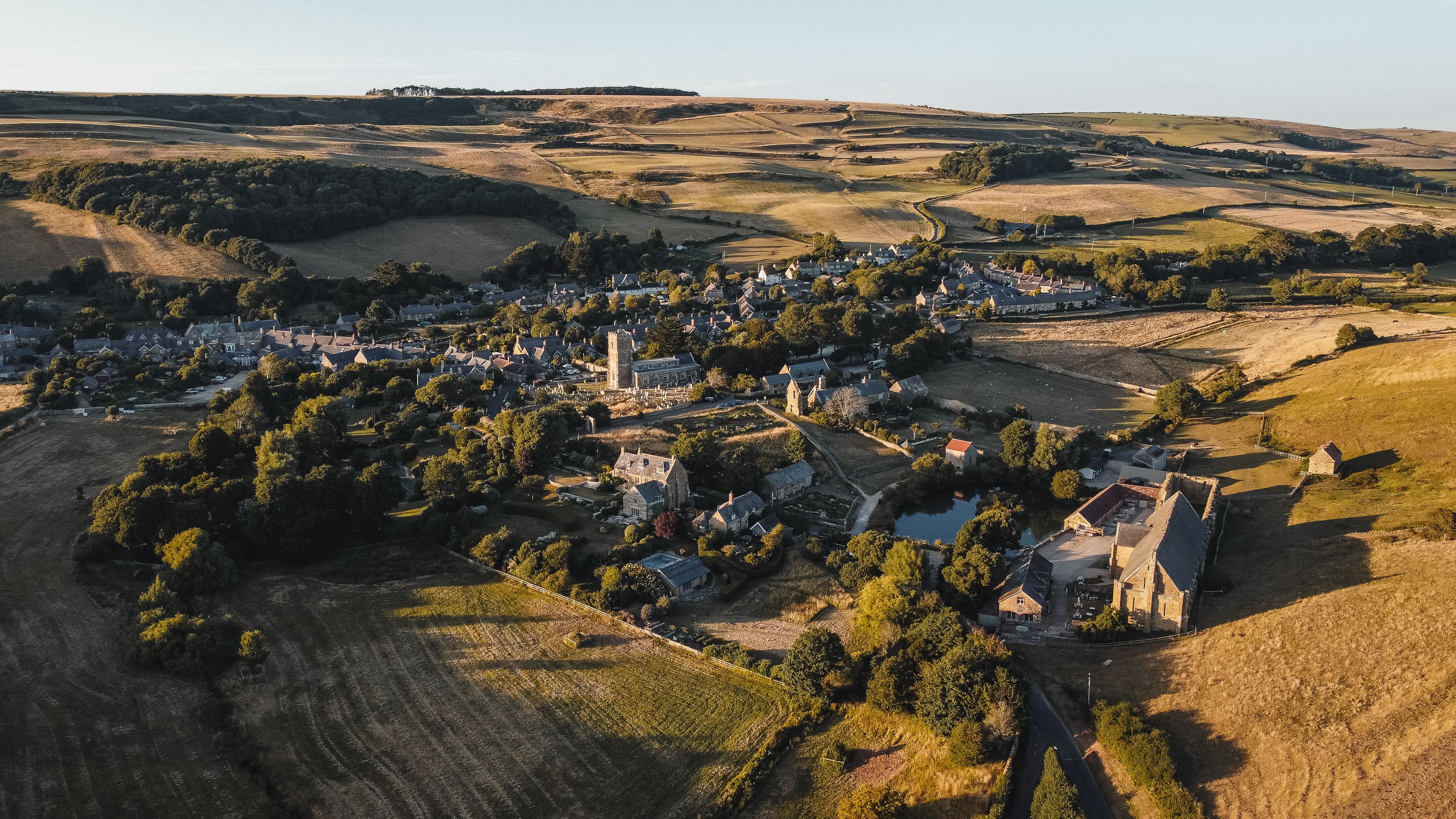 Scenic aerial view of the charming village of Abbotsbury in Dorset, England, surrounded by beautiful countryside.