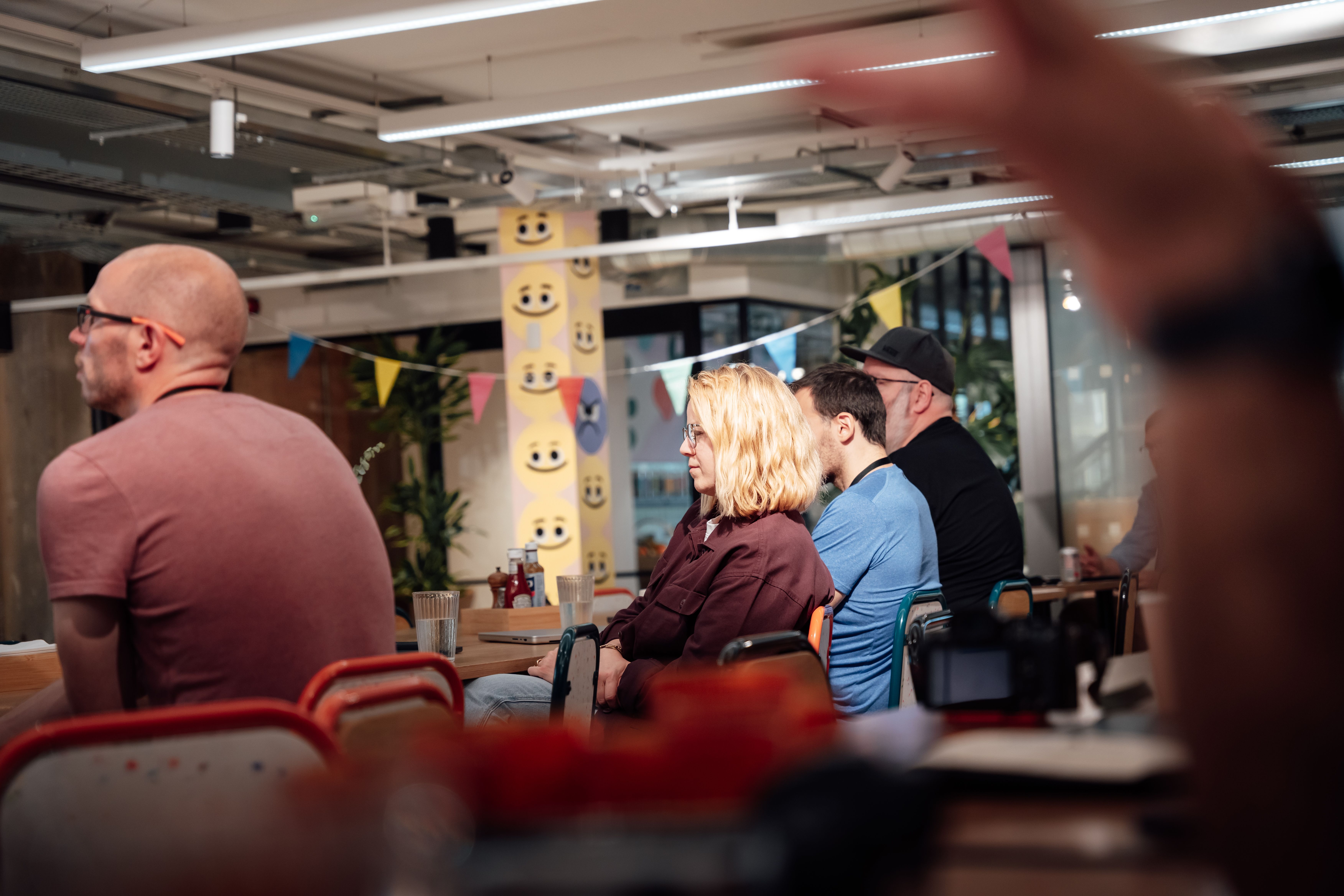 Casual office meeting with diverse adults in a modern workspace in London, UK.