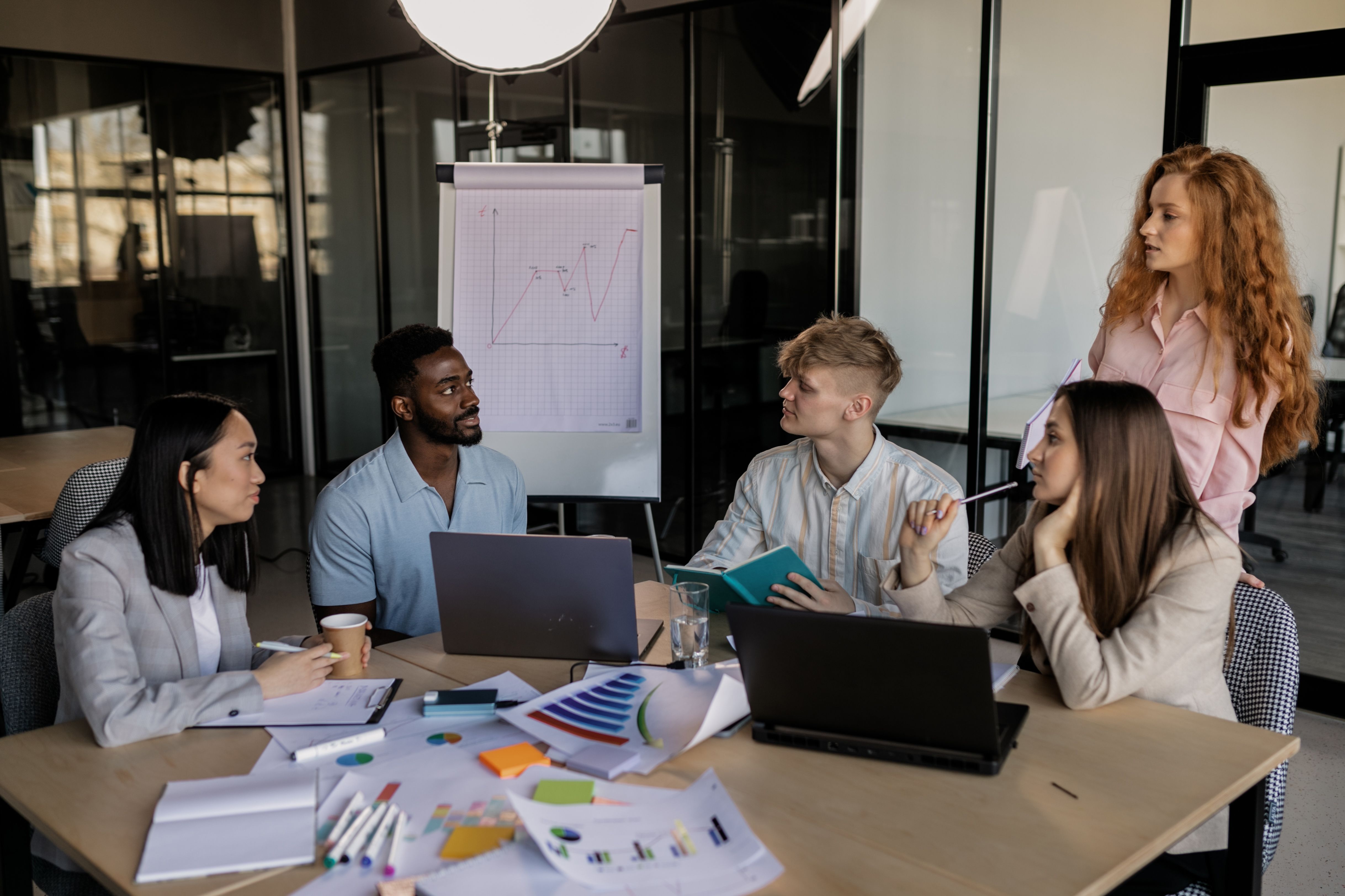 A diverse team discussing business strategy around a conference table in a modern office.