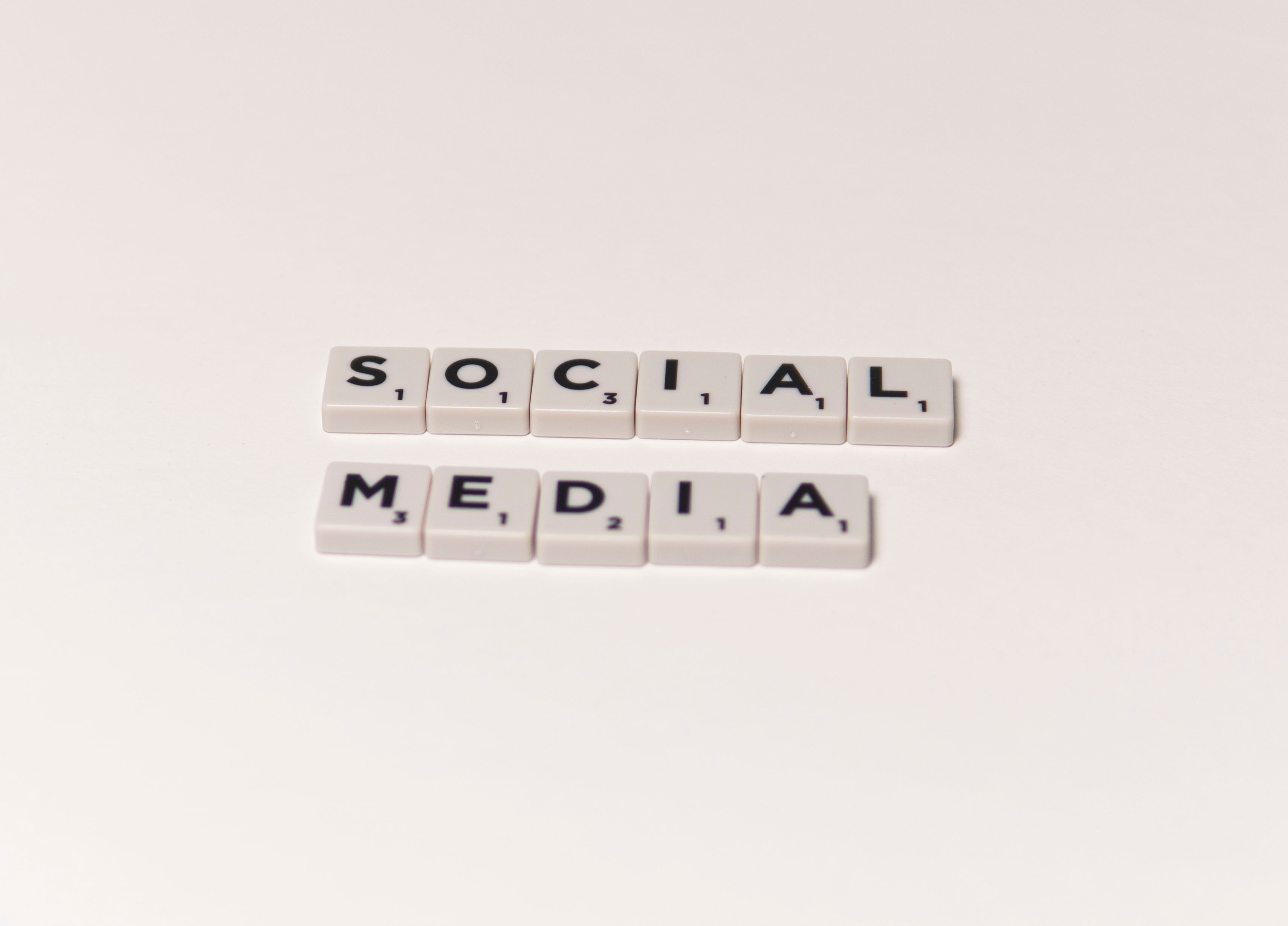 Scrabble tiles spelling 'social media' on a white background, representing digital communication concepts.